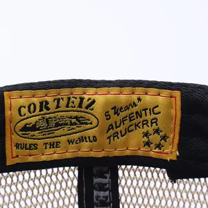 Corteiz trucker hat detail view showing the custom woven inner brand label and mesh panel structure.