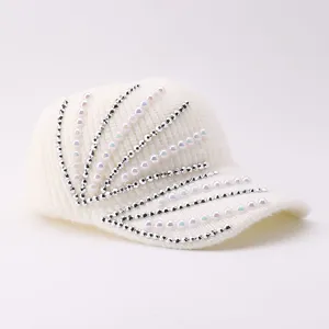 Close-up detail of winter warm white knitted baseball hat with shining pearls and silver beads.