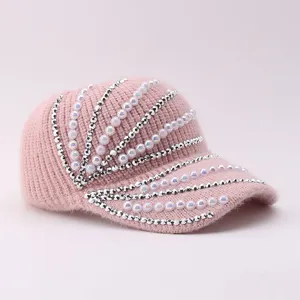 Pink knitted baseball cap detail view showing sparkling rhinestones and elegant faux pearl embellishments.
