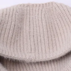 Close-up detail shot of winter warm knit beanie hat, soft fuzzy texture, elegant beige color.