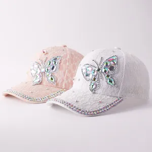 Detalle de la gorra de béisbol con mariposa de encaje y estrás, sombrero elegante