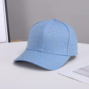 Close-up detail of light blue rhinestone baseball cap, sparkling crystal design elements.