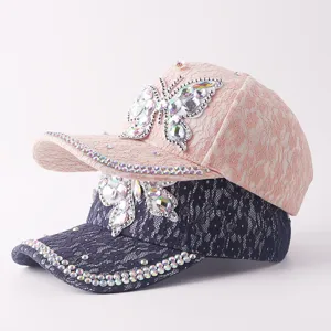 Vista detallada de la gorra de béisbol de encaje para mujer con mariposa de strass brillante.