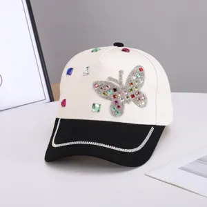 Detalle de mariposa de estrás en gorra de béisbol, con acentos brillantes y ala elegante.