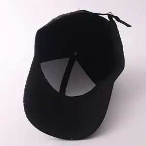Detailansicht einer schwarzen Baseballkappe mit funkelnden Strasssteinen und Metallschnalle.