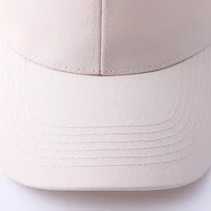 Vista detallada de gorra de béisbol minimalista de algodón puro con visera en color beige.