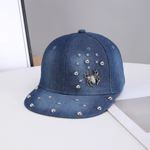 Detalle en primer plano de gorra de béisbol de mezclilla azul oscuro con tachuelas y araña.