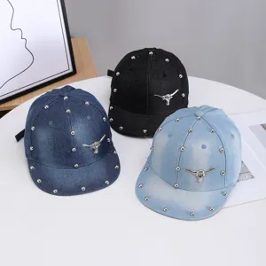 Gorra de béisbol plana de denim con remaches metálicos y emblema de toro para mujer.