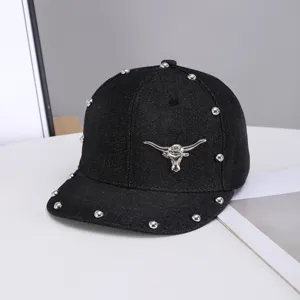 Gorra plana de mezclilla negra con cabeza de toro de metal y detalles de remaches.