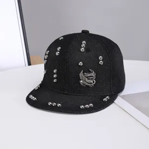 Gorra snapback de mezclilla negra con tachuelas metálicas y detalle de águila para mujer.