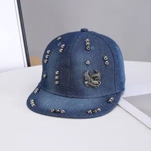 Moderna gorra de béisbol plana de denim con tachuelas metálicas y emblema de alas.