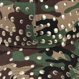 Detailopname van camouflage honkbalpet met metalen klinknagels en fijne textuur.