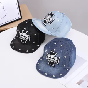 Gorra de béisbol de mezclilla con visera plana, parche de calavera y remaches metálicos.