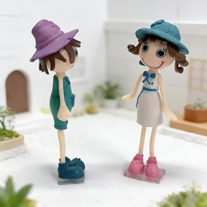 Close-up of cute 3D cartoon couple figurines fridge magnet in miniature garden scene