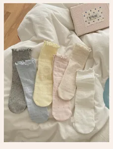 Gros plan de chaussettes mi-mollet à volants japonaises avec détails ajourés en cœur.