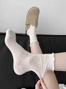 Detaillierte Ansicht atmungsaktiver Mesh-Spitzensocken mit süßem Rüschenrand für Damen.