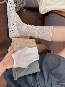 Dettaglio di calzini sottili trasparenti con bordo arrotolato, stile balletcore in cotone.