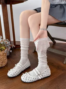 Calzini grigi slouch abbinati a scarpe basse Mary Jane a pois bianchi, stile carino.