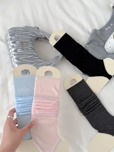 Detail view of ballet style stirrup leg warmers, thin knit calf socks in solid colors.