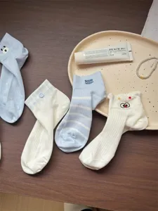 Vue détaillée de chaussettes courtes pour femmes en coton bleu et blanc avec jolis motifs.
