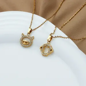 Détail de colliers en acier titane plaqué or avec pendentifs de signe du zodiaque cochon