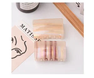 Detailed view of medium square hair claw clips with pearlescent and striped finishes