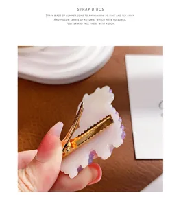 Macro detail van een schattige paarse acetaat alpaca haarclip met gouden clip