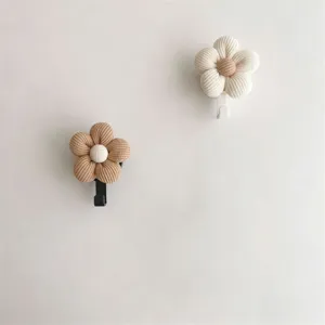 Detailed macro view of cute fabric flower wall hooks featuring soft ribbed knit textures.