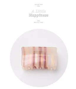 Detail showing the transparent jelly texture and colorful stripes of the hair claw clip