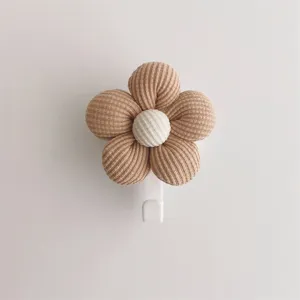 Detail shot of a minimalist brown fabric flower wall hook with a textured white center
