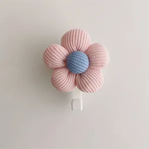Close-up of a cute pink and blue ribbed fabric flower wall hook with a white base