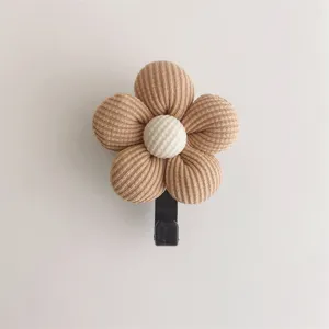 Macro detail of a cute beige ribbed fabric flower wall hook for home decoration.