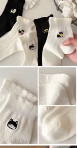 Close-up detail view of cute cat embroidered women socks with retro lace trim design fabric.