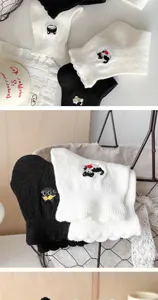 Close-up of cute cat embroidery and delicate lace trim on vintage style cotton socks.