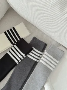 Detailed close-up of four-color ribbed knee high socks featuring classic four-bar stripes.