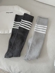 Grey Japanese preppy four bar striped calf socks for women, soft and stylish daily wear.