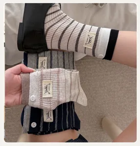 Vue détaillée de chaussettes mi-mollet à rayures de style coréen avec étiquette et boutons.