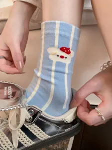 Primo piano di calzini di cotone a righe blu e bianche con un grazioso disegno di orsetto.