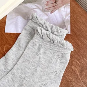 Grey women mid-tube socks with cute ruffle lace cuffs and delicate hollow bow knit patterns.