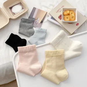 Detailansicht weicher, einfarbiger DamenSocken im Flat-Lay-Stil mit ästhetischen Büchern.