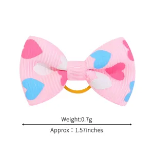 Dettaglio di un elastico per capelli con fiocco in nastro grosgrain rosa e cuori