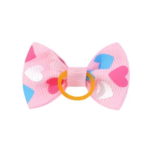 Dettaglio dell'elastico per capelli a fiocco rosa con cuori colorati