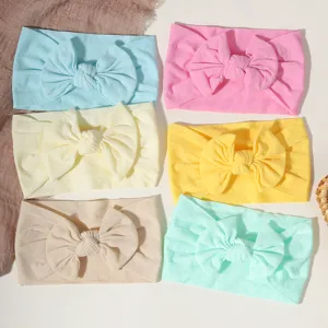 Detailansicht von sechs bunten Baby-Nylon-Schleifen-Stirnbändern in Pastelltönen.