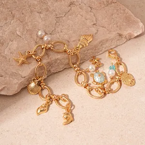 Detailed close-up of golden ocean themed charm bracelet with pearls and sea charms