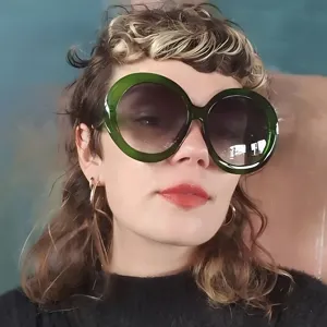 Oversized round sunglasses with stylish green frames for trendy women street style look
