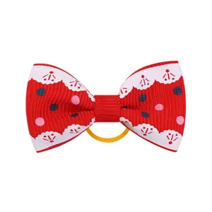 Vista dettagliata del fiocco per capelli in nastro grosgrain rosso con pois colorati