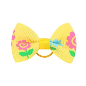 Primo piano di fiocco in nastro grosgrain giallo con stampa floreale per bambine