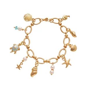 Elegant gold ocean charm bracelet featuring pearls, starfish, and turtle charms.