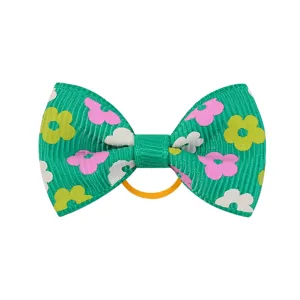 Dettaglio di un fiocco per capelli in nastro grosgrain verde con stampa floreale