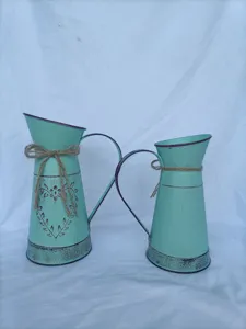 Λεπτομερής λήψη δύο vintage σιδερένιων βάζων με διακοσμητικούς φιόγκους από σπάγγο.